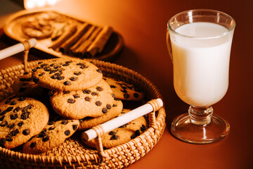 Freshly baked chocolate chip cookies served with cold milk in a cozy setting