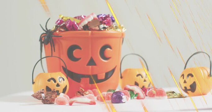 golden light streaks appearing and sweeping across jack o lantern bucket pails highlighting candies