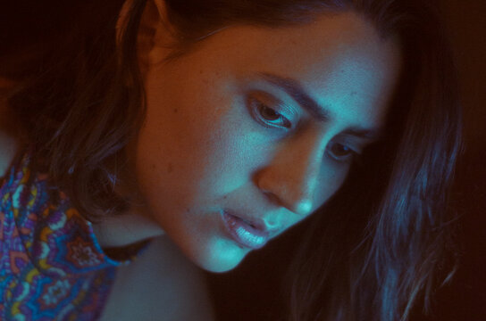 retrato oscuro de mujer con iluminacion cian y naranja