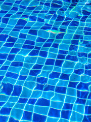 Aquatic Azure Mosaic: A vibrant pool shimmers with a mosaic of azure tiles beneath clear, inviting water, inviting a refreshing dip on a sunny day.