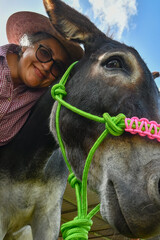 Rancher woman and a beautiful donkey pose for the camera.