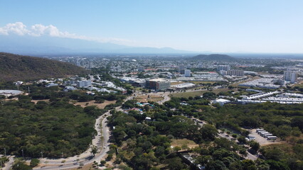 Aerial drone view of valledupar city in Colombia, buildings in background and blue sky.