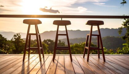 Wooden bar stools on a deck at sunset