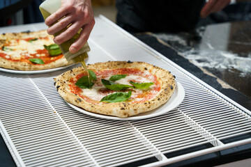 Drizzling olive oil on fresh pizza