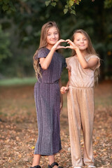 Fototapeta premium Portrait of two beautiful dressed children sisters outdoors.