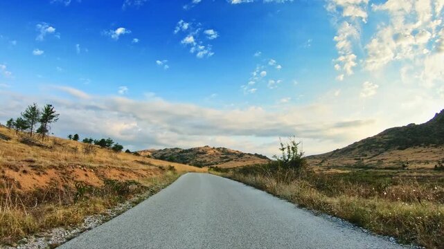 Local narrow road, mountain summer landscape, dry grass, POV driver perspective