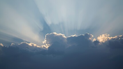 Light streams through a bank of cumulus clouds, illuminating the sky with a soft, ethereal glow.