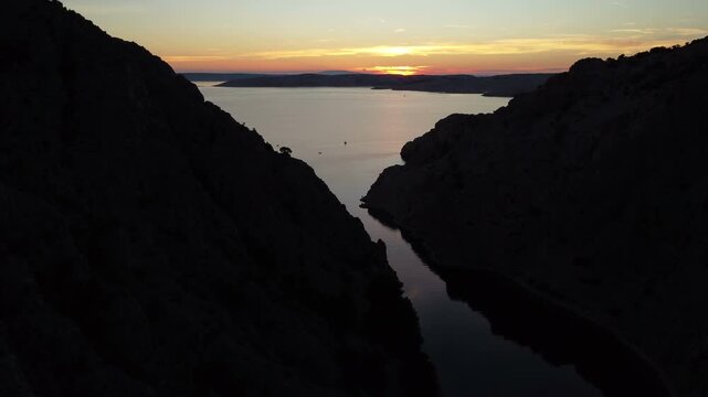 Aerial view of a dramatic canyon with turquoise water surrounded by rugged rocky cliffs. Zavratnica Bay in Croatia.