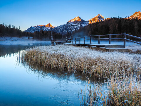 Frozen Lake Staz at sunrise with snowy mountains and copy space