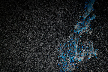 Abstract view of white and blue particles floating against a black background, resembling stars in space or underwater bubbles in darkness.