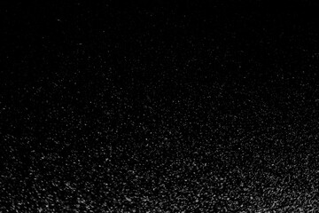 Black and white abstract image resembling snowfall at night or a starry sky, with countless white...