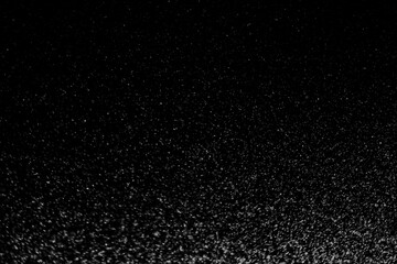 Black and white abstract image resembling snowfall at night or a starry sky, with countless white...