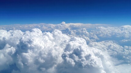 Fluffy white clouds cover the bright blue sky creating a peaceful scene above the landscape on a sunny day. The view evokes a sense of calm and tranquility.