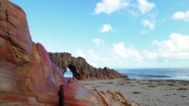 Striking rock formations meet the sea under a partly cloudy sky in brazil