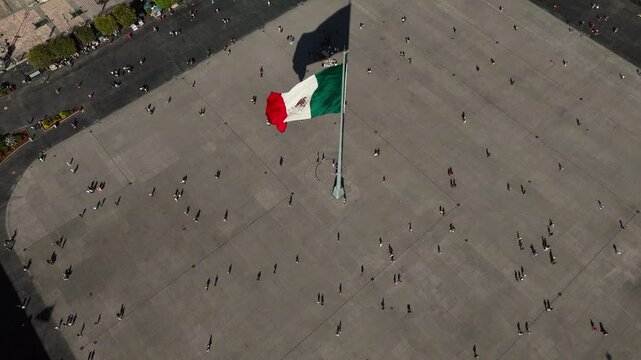 Bird&rsquo;s-eye static shot of the Mexican flag waving over Zocalo square in Mexico City, Mexico