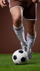 Fototapeta premium Male soccer player dribbling ball on grass field in action close-up