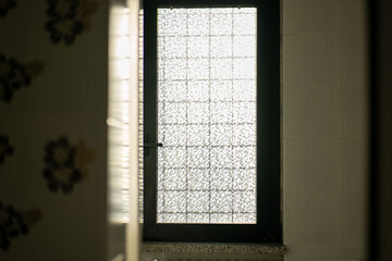 Beautiful textured glass window allowing soft light to enter a quiet room in a simple, modern building during the daytime © Akshatha