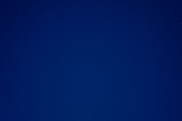 Obraz premium Night sky filled with stars and deep blue hue over a quiet landscape in late evening
