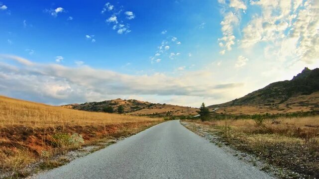 Amazing nature, golden meadows and blue sky with clouds, POV car travel