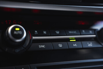 Close up view of the BMW X6 climate control panel with buttons for A or C, defrost, fan speed, and a SYNC button. Temperature set to 17.5degC. © Aerial Film Studio