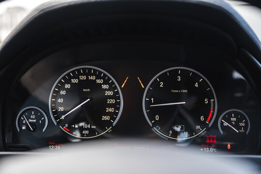 Close up view of a BMW X6 instrument cluster showing speedometer, tachometer, fuel and temperature gauges, and digital display with time and odometer.