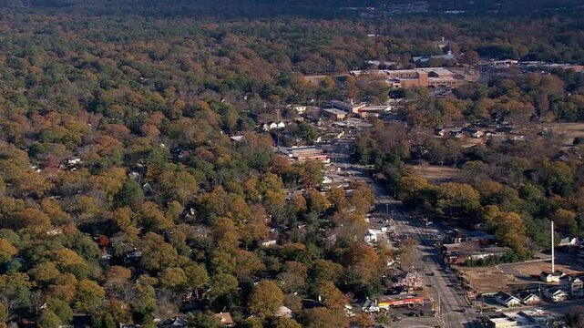 Aerial view shows a charming town nestled among colorful autumn trees