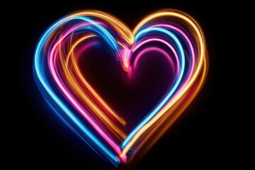 Vibrant heart shape formed by colorful light trails on black background