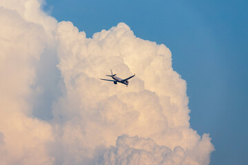 やや夕方の入道雲背景の飛んでいる飛行機