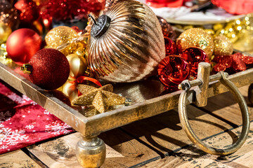glitter Christmas decoration background with gold and red balls on a vintage tray, selective focus 