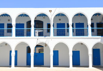 White Arched Building Facade with Blue Doors in Djerba, Tunisia