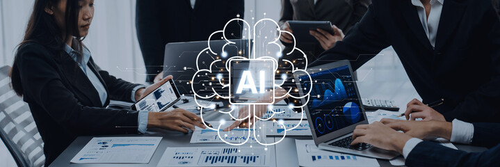 Diverse business team works together on artificial intelligence projects using laptops and data visualizations, highlighting innovation and collaboration in a modern corporate environment. Trope