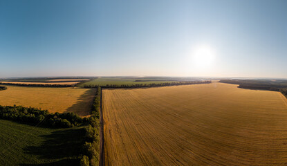 Aerial green and golden summer fields panorama in sunny rural Ukraine