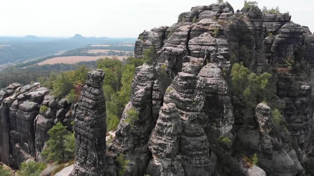 Dramatic rock formations rise above the lush forest in saxon switzerland, germany