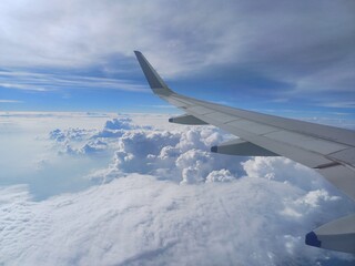view from airplane window with cloudy sky, wing of airplane, view from the plane.