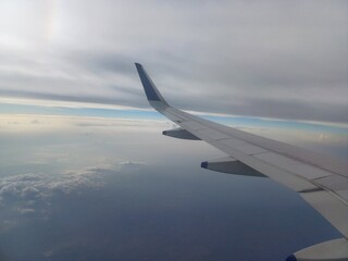 view from airplane window with cloudy sky, wing of airplane, view from the plane.