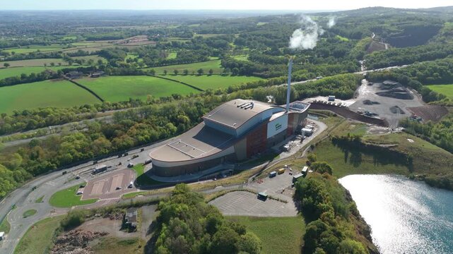 Scenic aerial drone shot of modern garbage incinerator plant in rural England, emissions from waste combustion, environmental concerns near Loughborough UK