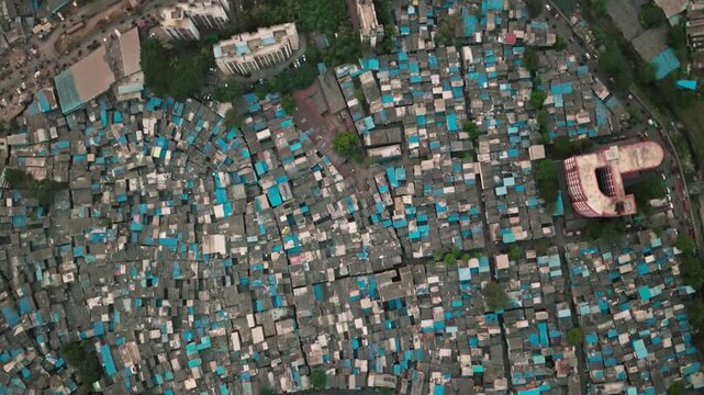Aerial view of densely packed slum dwellings with blue tarps in mumbai, india