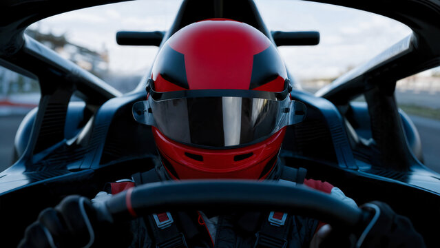 Close-up portrait of a driver inside the cockpit of a race car wearing a red helmet speeding on the track