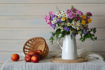 Wildflower bouquet in vase with fresh nectarines in the cottage