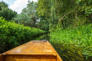 Rope on the bow of a wooden punt travelling through the lush greenery of the River Stour in Canterbury, Kent, UK.