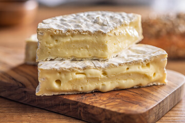 Camembert cheese on wooden table. French cheese with mold on the surface.