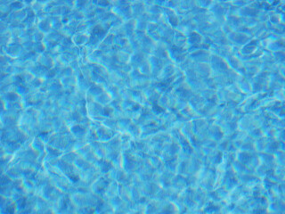 Clear Blue Swimming Pool Water Surface with Sunlight Reflections