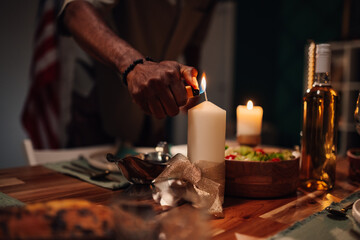 Chef lighting candle on table with american flag in background