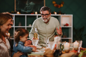 Grandfather making a toast during thanksgiving dinner with family