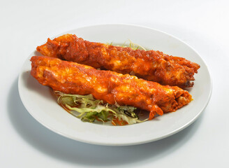 Shish Kebabs Covered in a Rich Red Sauce on a White Plate isolated on white background side view of Middle Eastern food