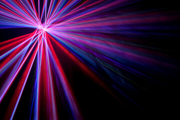 Real laser lights with colorful beams in smoke on black background &ndash; concert and party concept