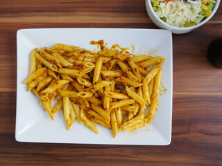 Plate of pasta with sauce on a wooden table