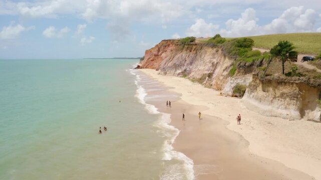 Aerial view of a beautiful beach with cliffs and turquoise water on a sunny day