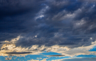 dark storm clouds with a patch of blue sky at sunset