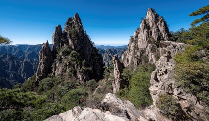 A breathtaking vista of rugged mountain peaks piercing a vibrant blue sky, showcasing a dramatic landscape of rock formations and lush greenery.